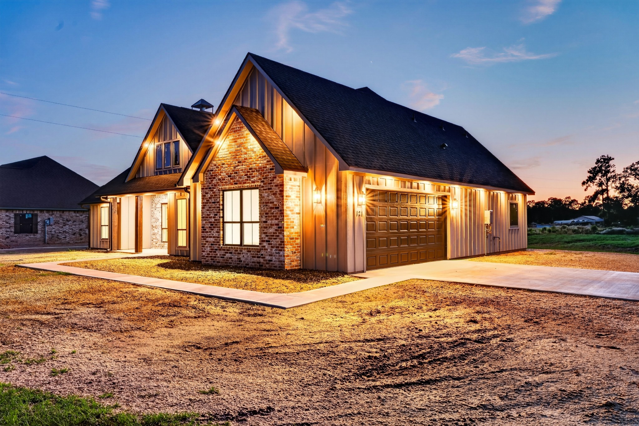 Warmly illuminated brick and siding home at dusk, photographed by Fabled Lens